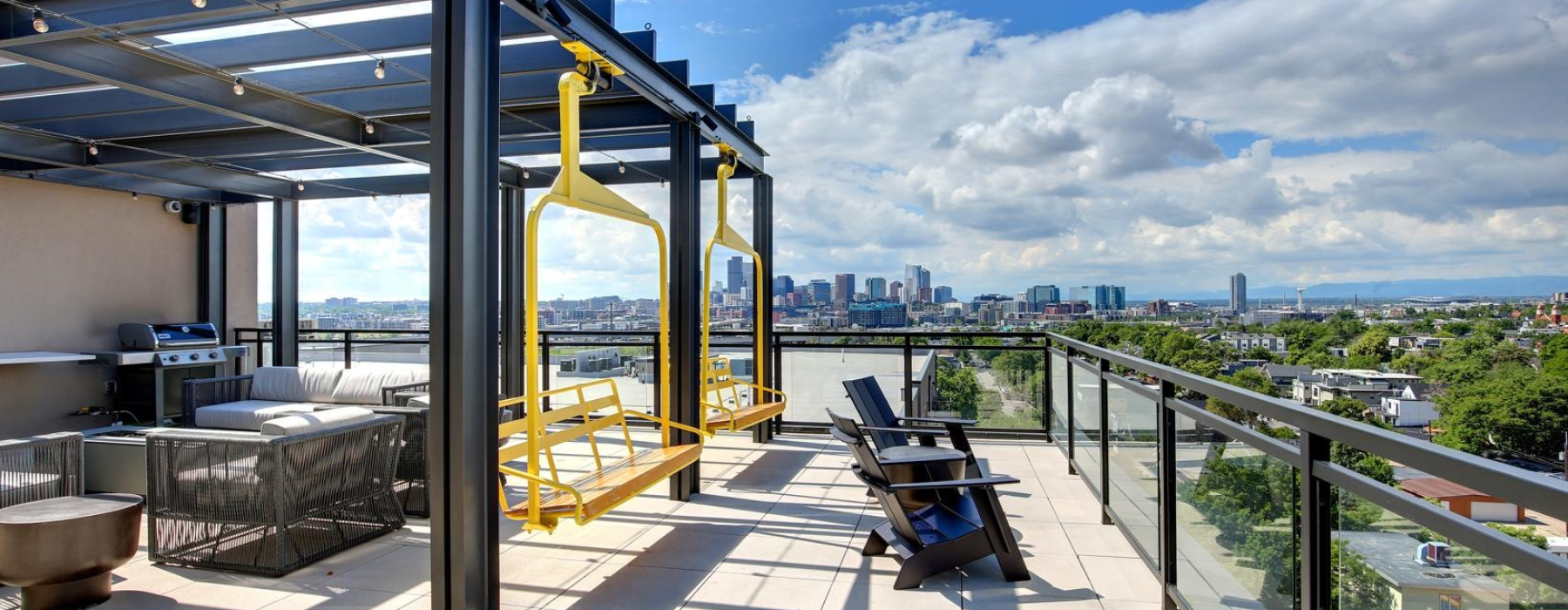 Modern rooftop patio featuring yellow chairlift swings.